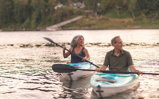 senior couple in kayaks on a lake