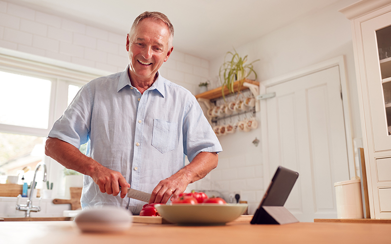 older man using amazon echo for seniors to help in the kitchen